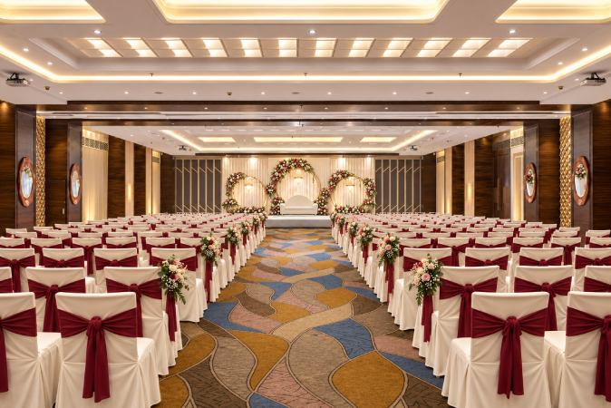 Express Royale wedding venue in Nashik with decorated chairs, floral 
aisle arrangements, elegant stage and spacious event hall